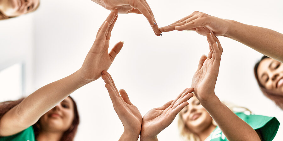 Group of young volunteers woman smiling happy make heart symbol