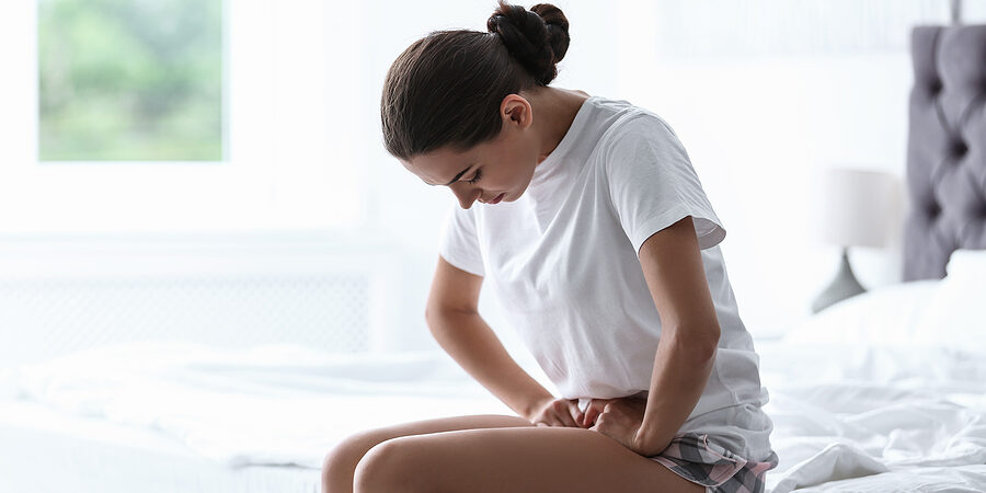 Young Woman Suffering From Menstrual Cramps At Home. Gynecology